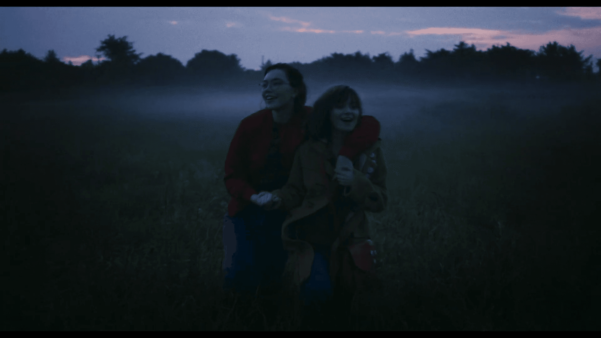 Two women dressed in bright colours are standing next to each other