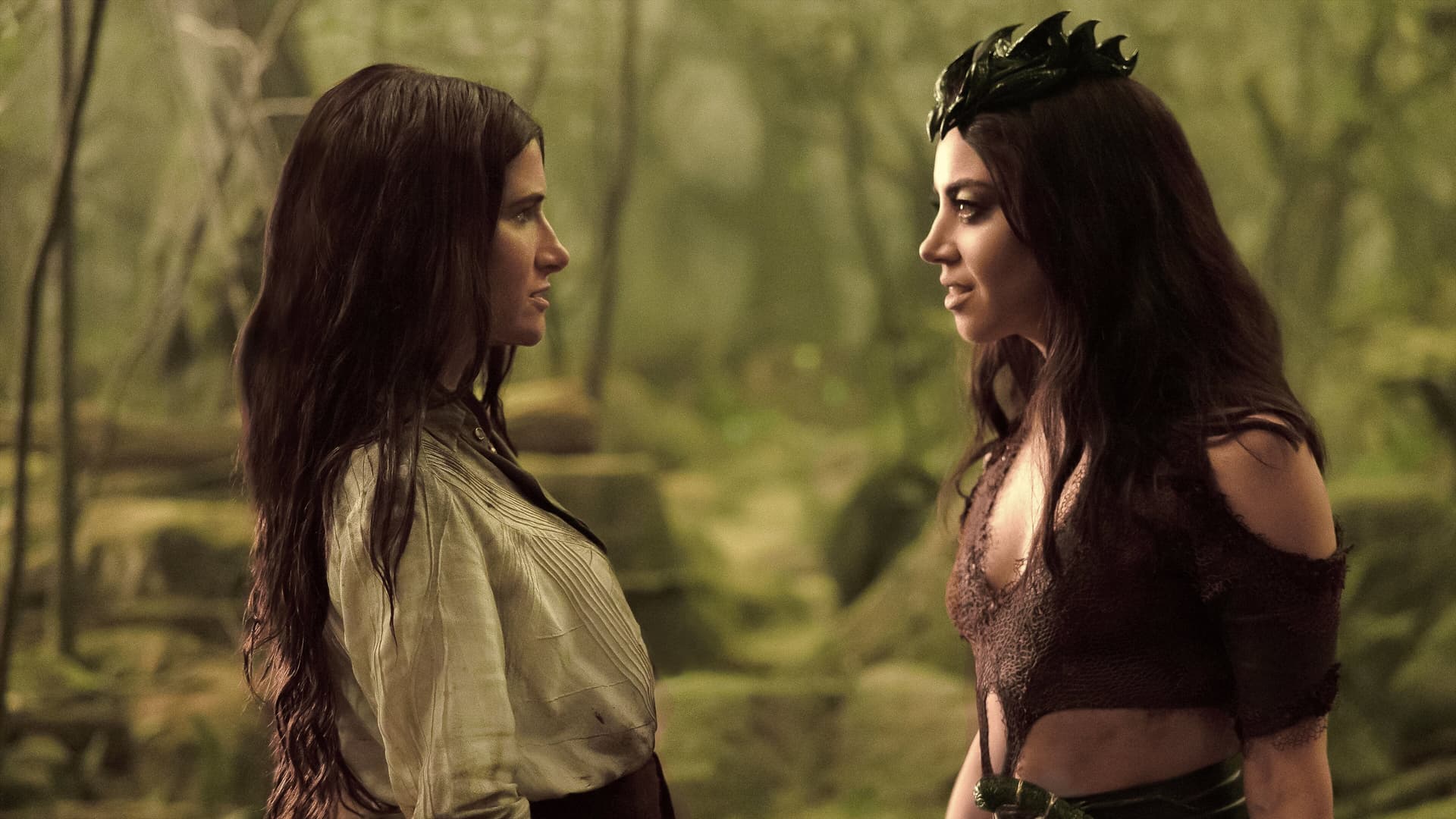 Two women, portrayed by Kathryn Hahn and Aubrey Plaza, are looking at each other in the woods.